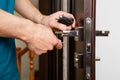 a man repairing a door knob. locksmith fixing a wooden door