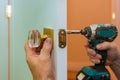 Man repairing the doorknob closeup of worker hands installing new door locker