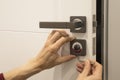 man repairing the doorknob. closeup of worker& x27;s hands installing new door locker Royalty Free Stock Photo