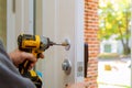 man repairing the doorknob. closeup of worker& x27;s hands installing new door locker Royalty Free Stock Photo