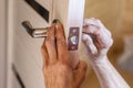 Man repairing the doorknob. closeup of workers hands installing new door locker Royalty Free Stock Photo