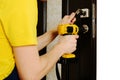 a man repairing a doorknob. Handyman repair the door lock in the room.