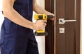 a man repairing a doorknob. Handyman repair the door lock in the room.