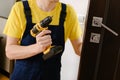 a man repairing a doorknob. Handyman repair the door lock in the room.