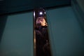 Man repairing an elevator at night inside a shaft of a high-rise building, front and background blurred with bokeh effect