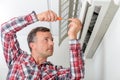 Man repairing his air conditioning system Royalty Free Stock Photo