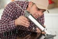 man repairing kitchen with silicon gun Royalty Free Stock Photo
