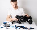 Man repairing a radio-controlled model car buggy. On the table are tools for repair. Royalty Free Stock Photo