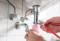 Man repairing sink trap with adjustable pipe wrench Royalty Free Stock Photo