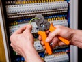 The man is repairing the switchboard voltage with automatic switches.