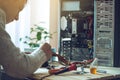 Man repairman is trying to fix using the tools on the computer that is on a workplace in the office Royalty Free Stock Photo