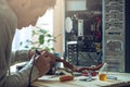 Man repairman is trying to fix using the tools on the computer that is on a workplace in the office Royalty Free Stock Photo