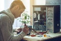 Man repairman is trying to fix using the tools on the computer that is on a workplace in the office Royalty Free Stock Photo