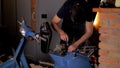 Man repairs a blue scooter or motorcycle in home.