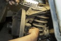 A man repairs a car. Repair of the machine. The hand of the machine is next to the spring in the car, and the second
