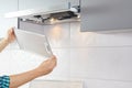 Man repairs range hood in the kitchen. Replacement filter in a cooker hood Royalty Free Stock Photo
