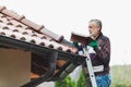 Man repairs tiled roof of house close up Royalty Free Stock Photo