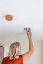 A man replaces an energy-saving light bulb in a ceiling light Royalty Free Stock Photo