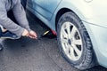 Man replaces flat tyre on road. Car tire leak because of nail pounding Royalty Free Stock Photo