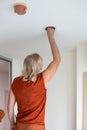 A man replaces an LED light bulb in a ceiling light Royalty Free Stock Photo