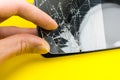 Man replacing the broken tempered glass screen protector. Crashed smartphone. Close up