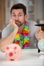 man resigned to smashing piggybank for travel funds Royalty Free Stock Photo