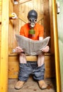 Man in respirator reading newspaper in wooden village WC