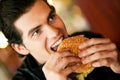 Man in restaurant eating hamburger Royalty Free Stock Photo