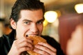 Man in restaurant eating hamburger Royalty Free Stock Photo