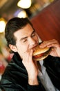 Man in restaurant eating hamburger Royalty Free Stock Photo