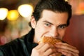Man in restaurant eating hamburger Royalty Free Stock Photo