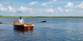 Man resting on the lake, riding a boat with oars, there is a place for the inscription Royalty Free Stock Photo