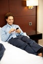 Man resting in luxurious bed and messaging Royalty Free Stock Photo