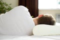 A man is resting on an orthopedic pillow. The concept of taking care of your health. Healthy sleep