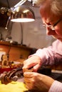 Man Restoring Violin In Workshop