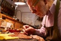 Man Restoring Violin In Workshop