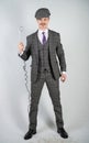 Man in a retro suit stands and holds a vintage water boiler on a white Studio background alone