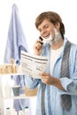 Man reviewing document while shaving