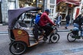 Man on rickshaw taxi bike circulating in Amsterdam, Netherlands