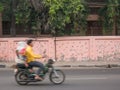 A man ride his bike with a woman behind him.