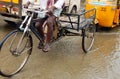 Man ride tricycle or rickshaw in rain water flooded road