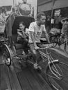 Man ride tricycle and woman is passenger in market Royalty Free Stock Photo