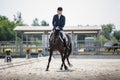 Man rider and black stallion eventing horse trotting leg-yield during equestrian dressage competition Royalty Free Stock Photo