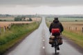 a man rides a bicycle on an empty road among a beautiful field, the concept of cycling travel generative ai