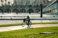 A man rides a bicycle in the Queen Sofia Palace of Arts Park, futuristic architecture