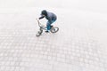 Man rides a BMX bike on a pavement overhead. Minimalist photo of cyclist who rides on BMX in the square