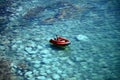 Man riding red inflatable boat on green sea waters Royalty Free Stock Photo