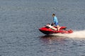 A man rides a red jet ski on the river. Royalty Free Stock Photo