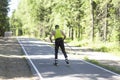 A man rides roller skis in a summer park.Fitness on the street Royalty Free Stock Photo