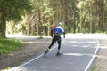 A man rides roller skis in a summer park.Fitness on the street Royalty Free Stock Photo